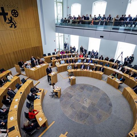 Zu sehen ist das Plenum aus der Perspektive der Zuschauertribüne.