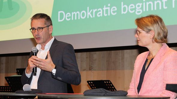 Landtagspräsident Hering spricht vor einem Pult zu den Gästen des 13. Demokratietages in Ingelheim.