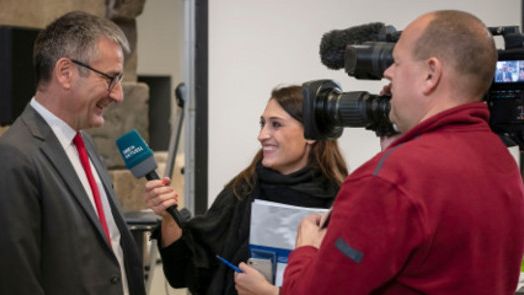 Eine Moderatorin und ein Kameramann interviewen Hendrik Hering