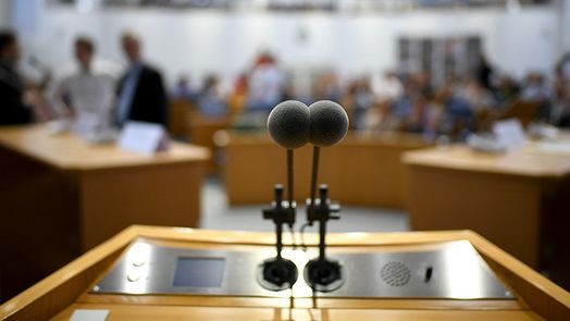 Nahaufnahme des Rednerpultes im Plenarsaal - Fokus auf den Mikrophonen