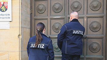 Eine Justizbeamtin und ein Justizbeamter betreten das Landgericht Rheinland-Pfalz