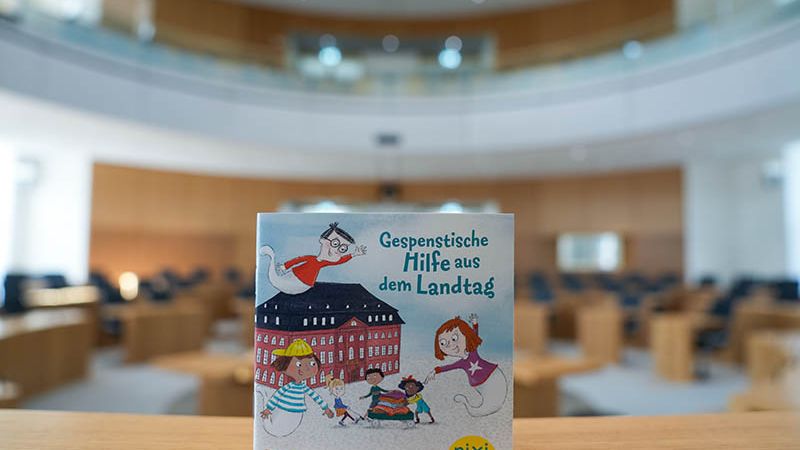 Das neue Pixi-Buch „Gespenstische Hilfe aus dem Landtag“. Hier zu sehen ist ein Bild vom Pixi-Buch augenommen im leeren Plenarsaal.