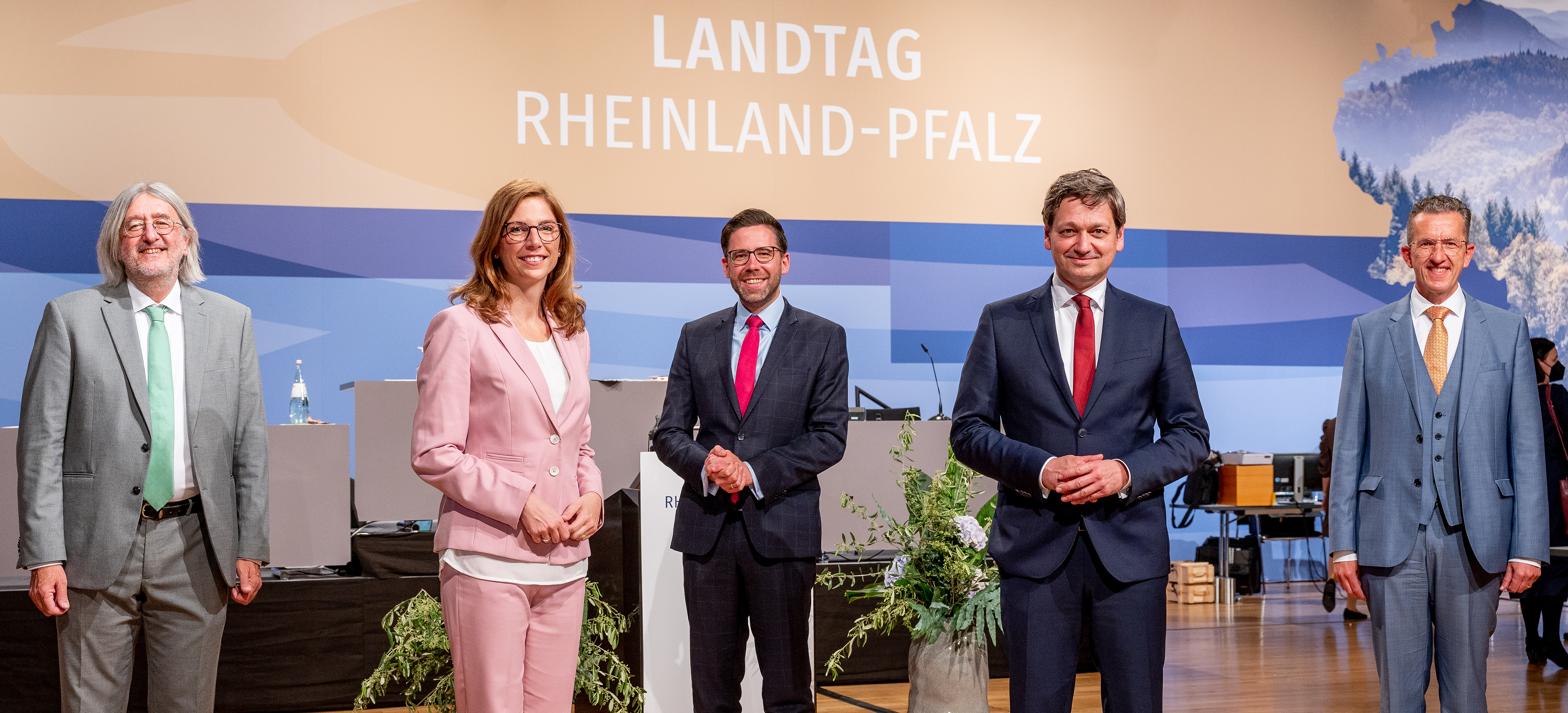Die Fraktionsvorsitzenden stehen auf der Rednerflächen vor dem Logo des Landtags Rheinland-Pfalz.