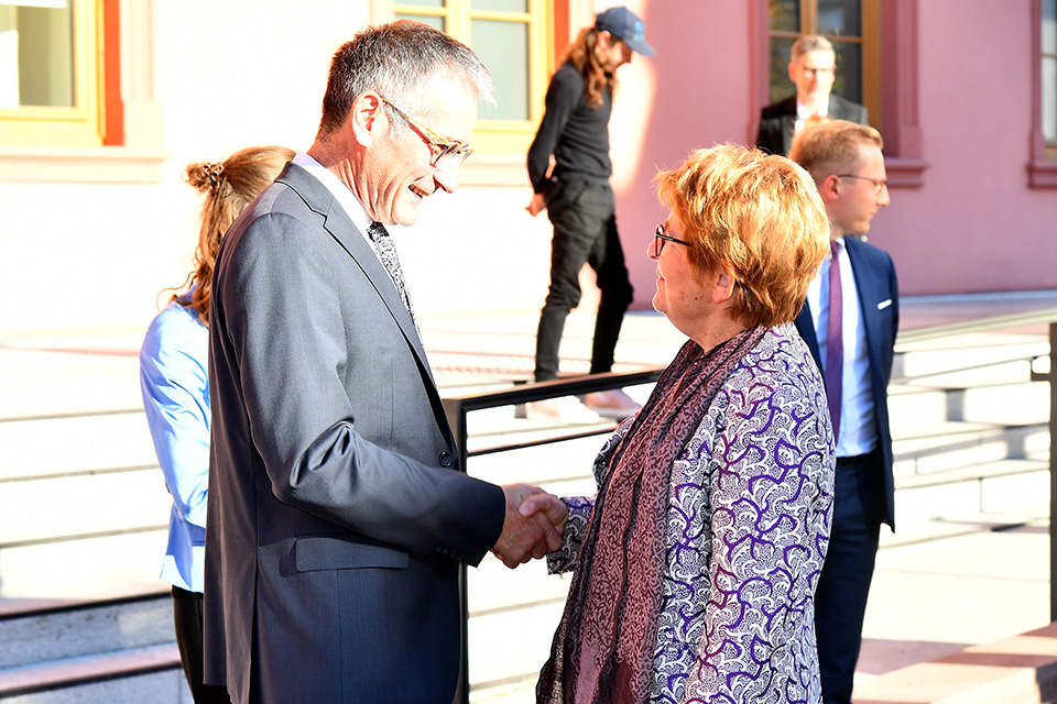 Die Begrüßung findet vor dem Deutschhaus in Mainz statt. Hendrik Hering und Marie-Guite Dufay schütteln zur Begrüßung die Hände.