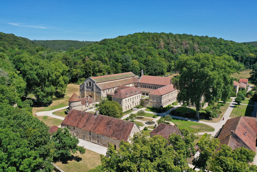 Luftbild der L'Abbeye de Fontenay; sommerliche Wälder umgeben die historischen Gebäude