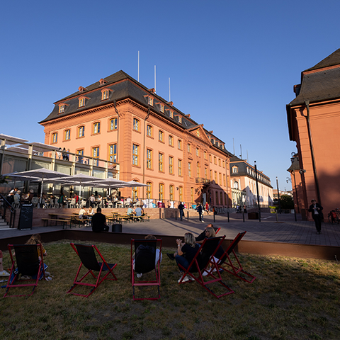 Zu sehen sind die Gebäude teils in der Sonne und teils im Schatten, der untergehenden Sonne.
