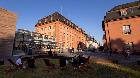 Zu sehen sind die Gebäude teils in der Sonne und teils im Schatten, der untergehenden Sonne.