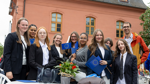Junge Frauen halten Europaflaggen in der Hand.