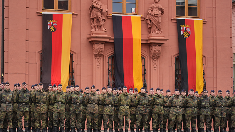 Zu sehen ist eine große Gruppe von Soldaten, die vor dem Landtagsgebäude stehen. Im Hintergrund hängen drei Deutschlandfahnen.
