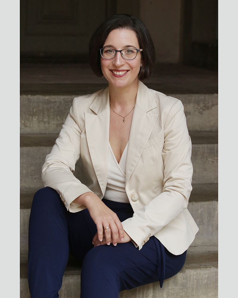 Portrait von Prof. Vanessa-Isabelle Reinwand-Weiss, sitzend auf einer Treppe