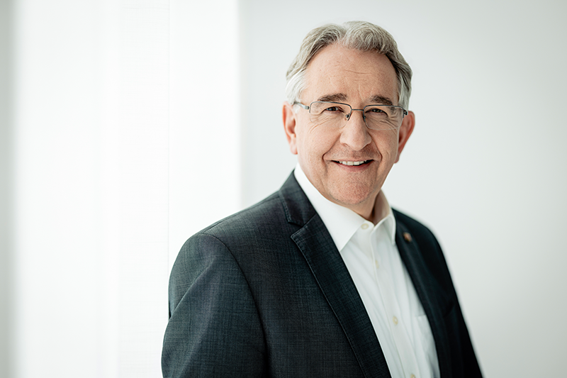Zu sehen ist ein Mann. mit leicht lächelndem Blick. 