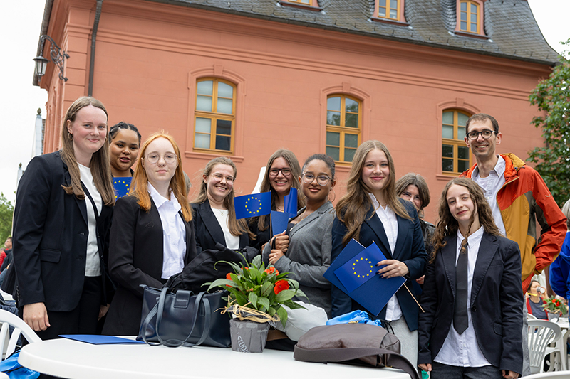 Junge Frauen halten Europaflaggen in der Hand.