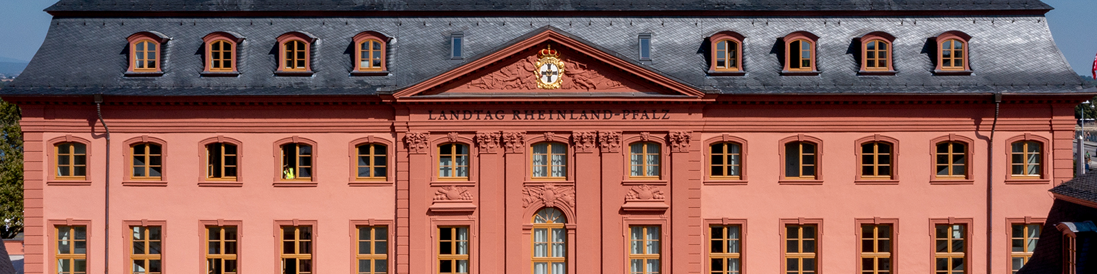 Zu sehen ist die Front des Deutschhauses. Ein gro&szlig;es Geb&auml;ude in rotem Sandstein.