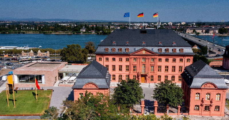 Außenansicht des sanierten Deutschhauses mit Kavalliersbauten, Landtagsrestaurant und dem Kunstwerk "Drei Fahnen"